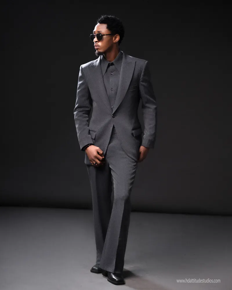 Grey suit, walking pose, dark backdrop