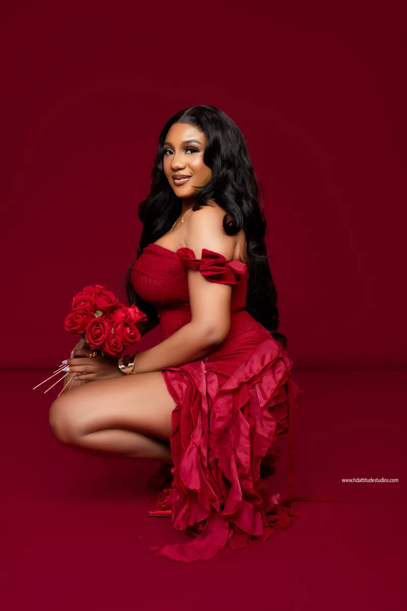 Kneeling with a red rose bouquet, romantic red-on-red styling