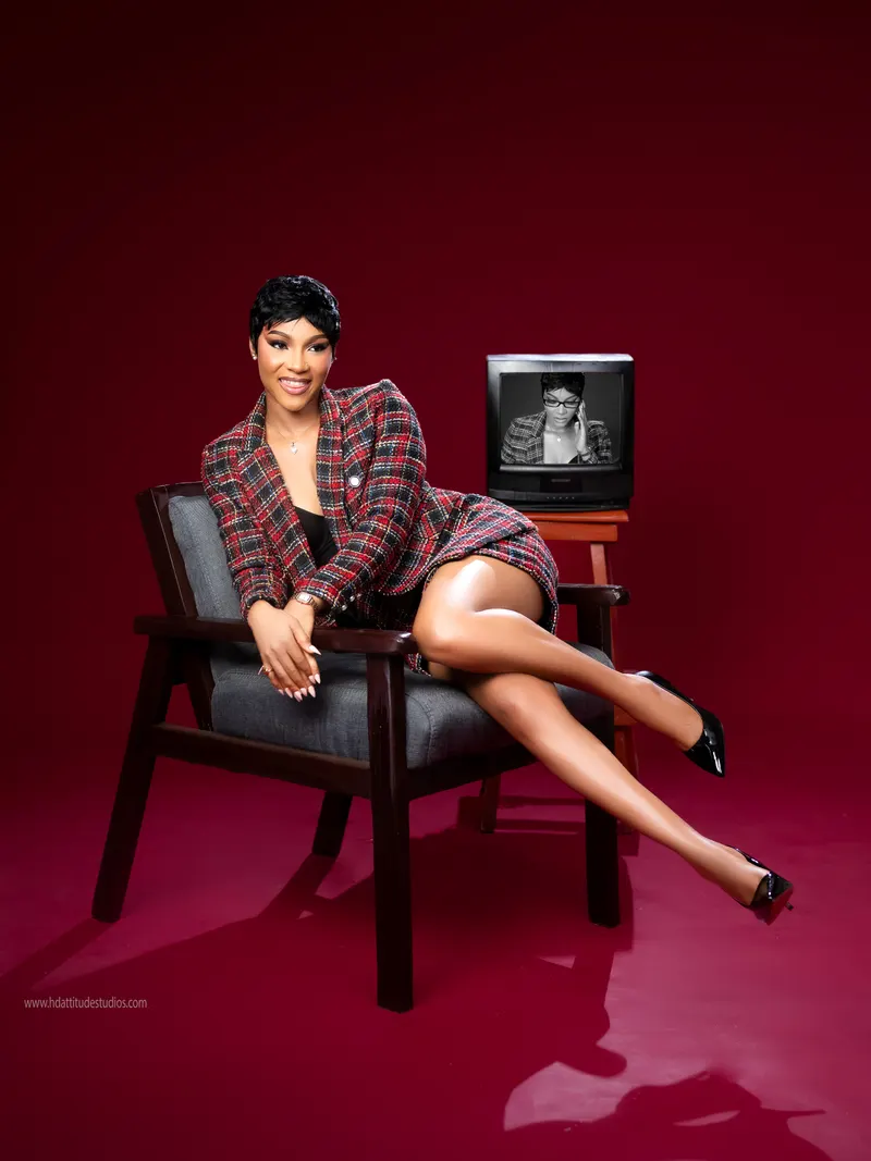 Same plaid set, standing beside retro TV prop showing photo-within-photo concept