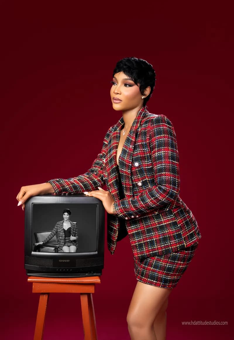 Same plaid set, profile pose beside vintage TV on stool