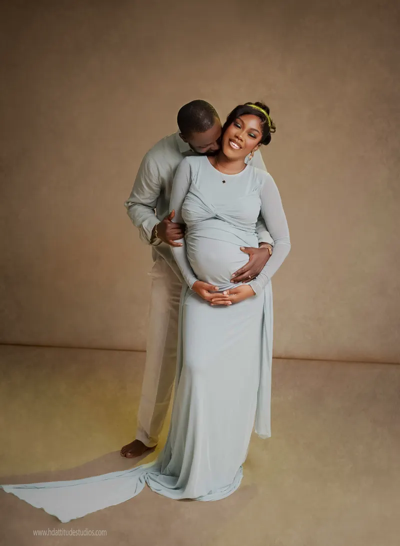 Couple maternity portrait, sage gown, husband embracing bump from behind