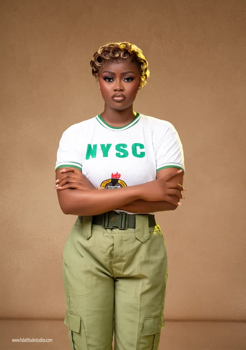 Same NYSC set, close-up arms-crossed portrait