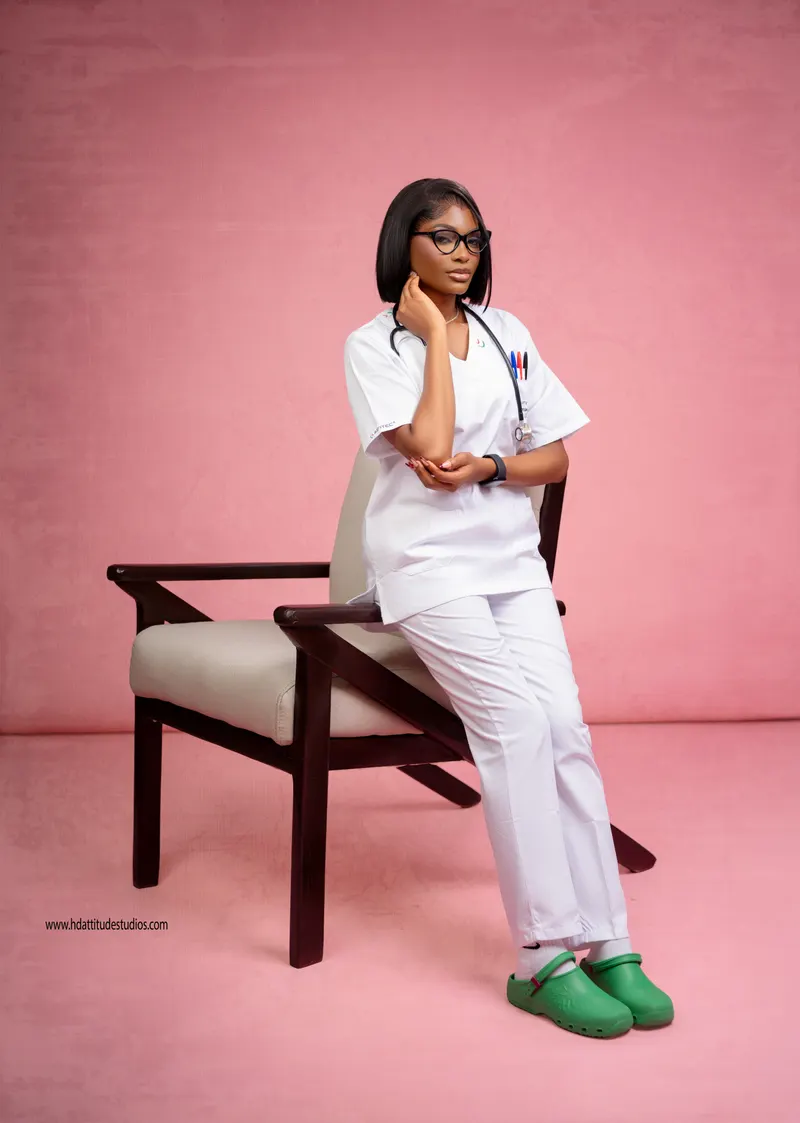 Nurse/scrubs occupational portrait, stethoscope, pink studio backdrop, seated