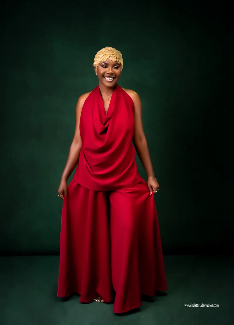 Same red-outfit set, standing full-length twirl pose, green backdrop