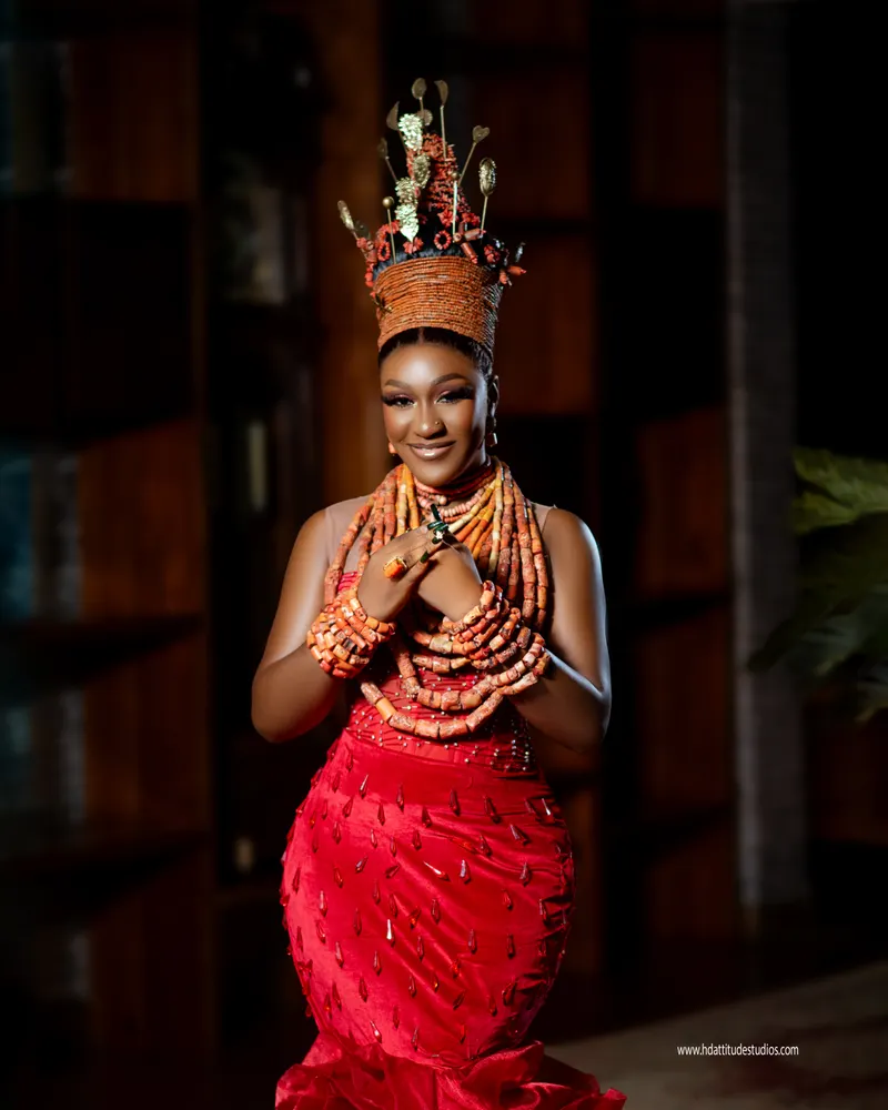 Coral-crowned bride, hands clasped at chest, softer smile