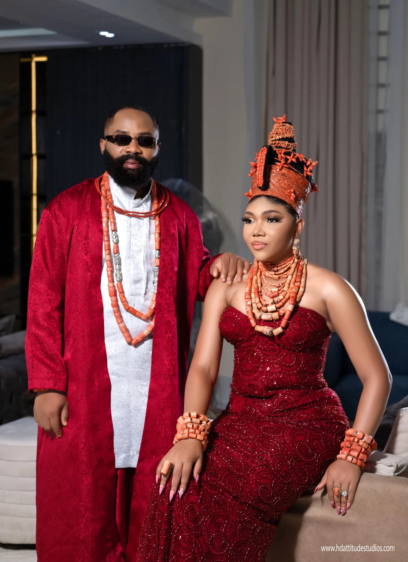 Couple in matching red traditional wear with elaborate coral coronet headdress